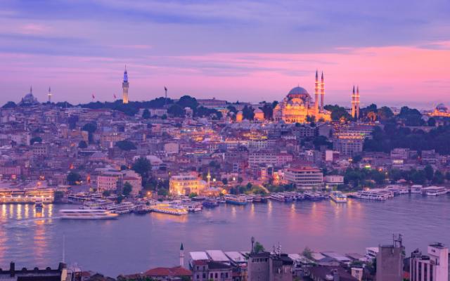 Sunset in Istanbul as viewed from Galata Tower with the city covered in purple, orange and blue evening lighting